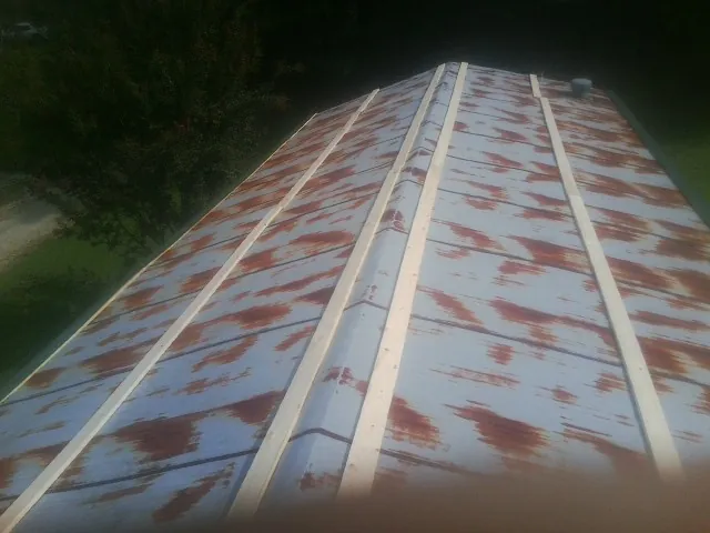 Rusted metal roof panels with new wood purlins before replacement — Storm Damage Roof Repair in Grandview by Roofing Brothers